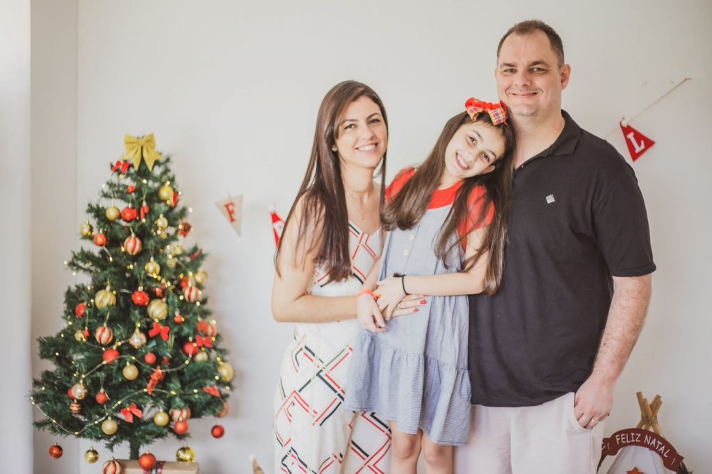 Um pai, uma Mãe e sua Filha em um ensaio de natal