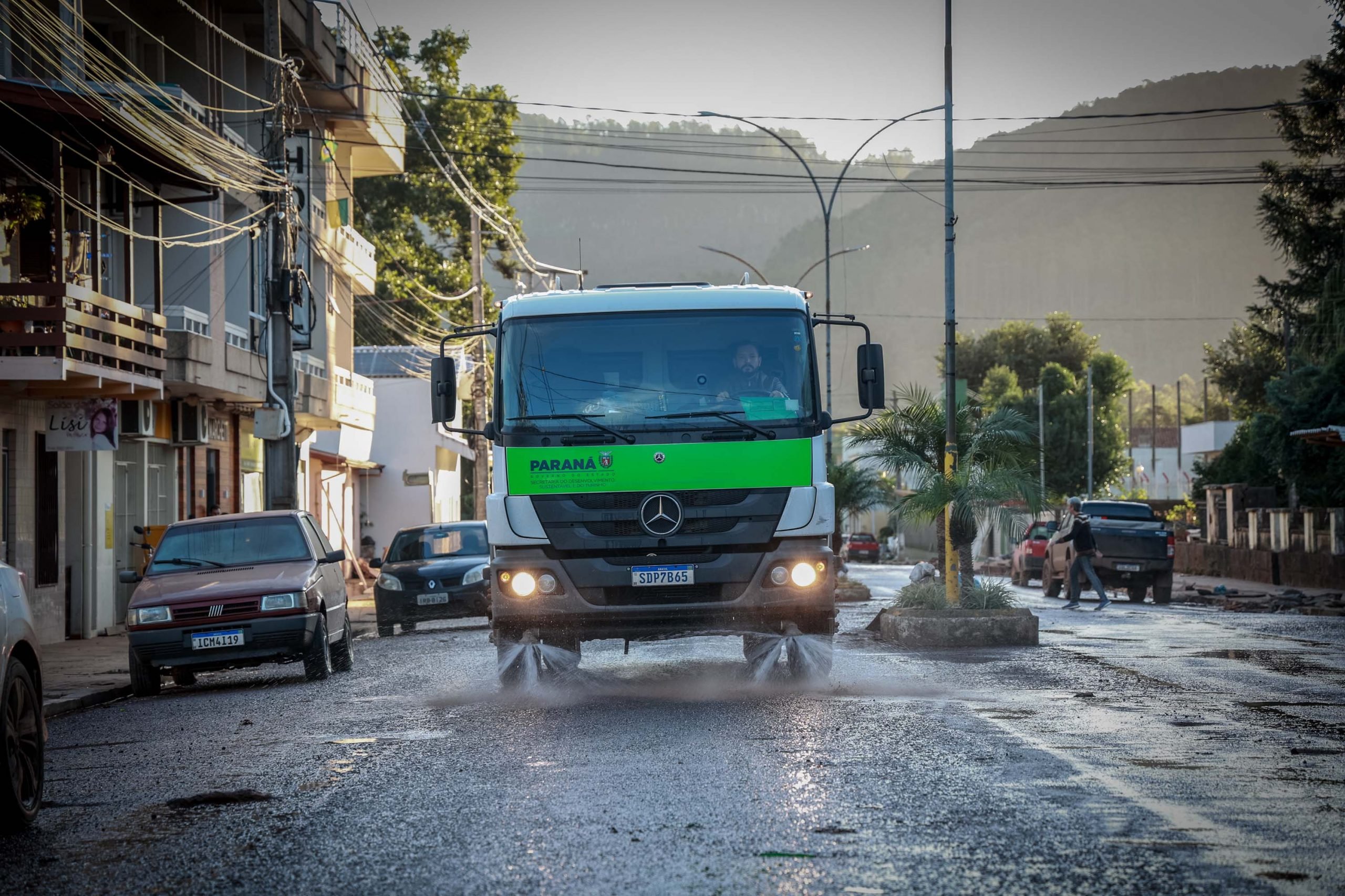 Imagem mostra um caminhão de limpeza do IAT, limpando uma rua no Rio Grande do Sul