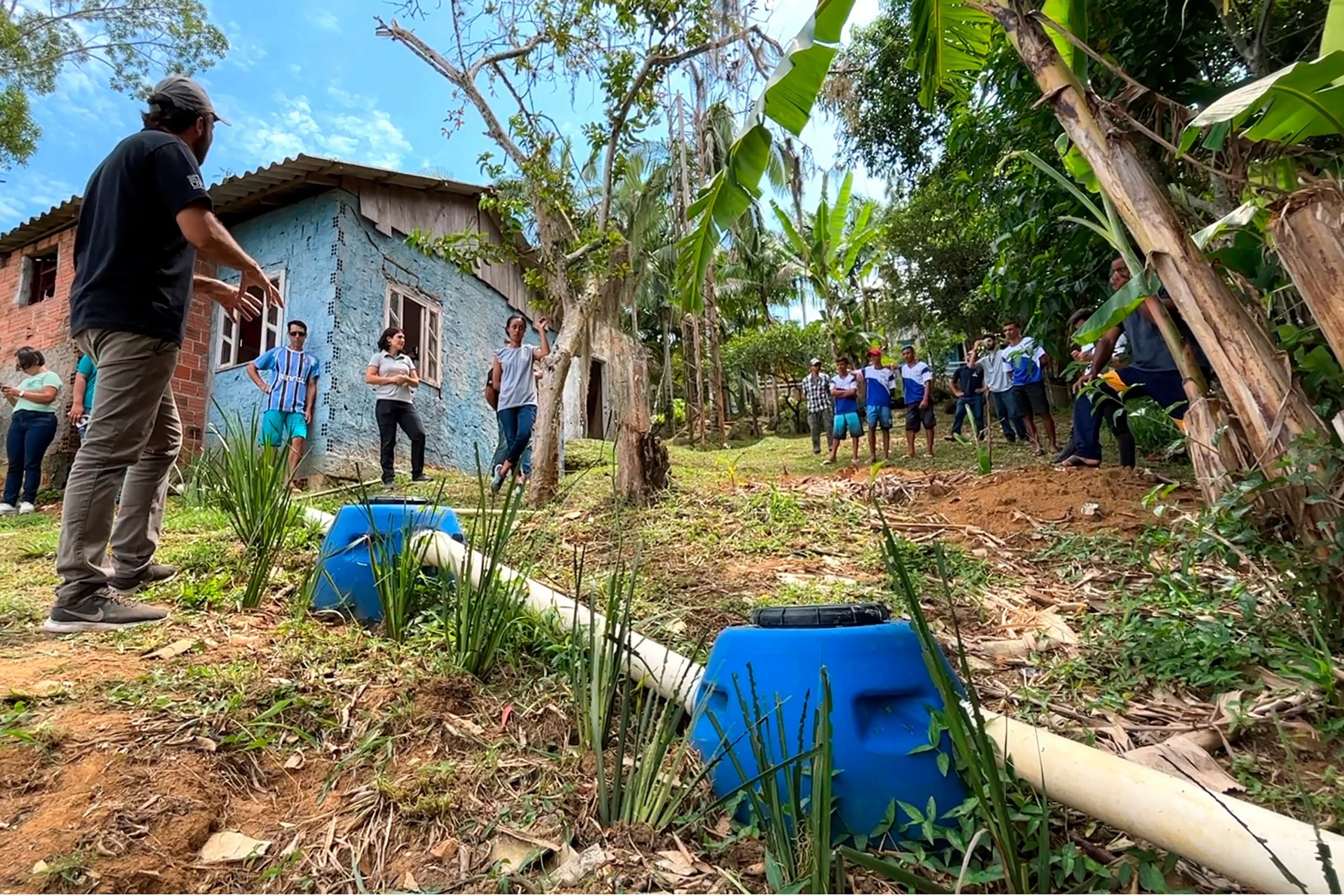 A imagem mostra pessoas em uma casa siuada na ilha de eufrasina para aplicar o projeto de sistema de esgoto