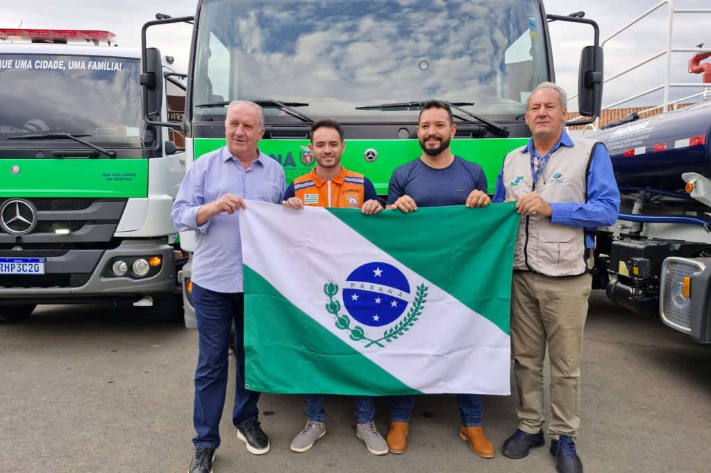 Voluntários segurando a bandeira do Paraná.