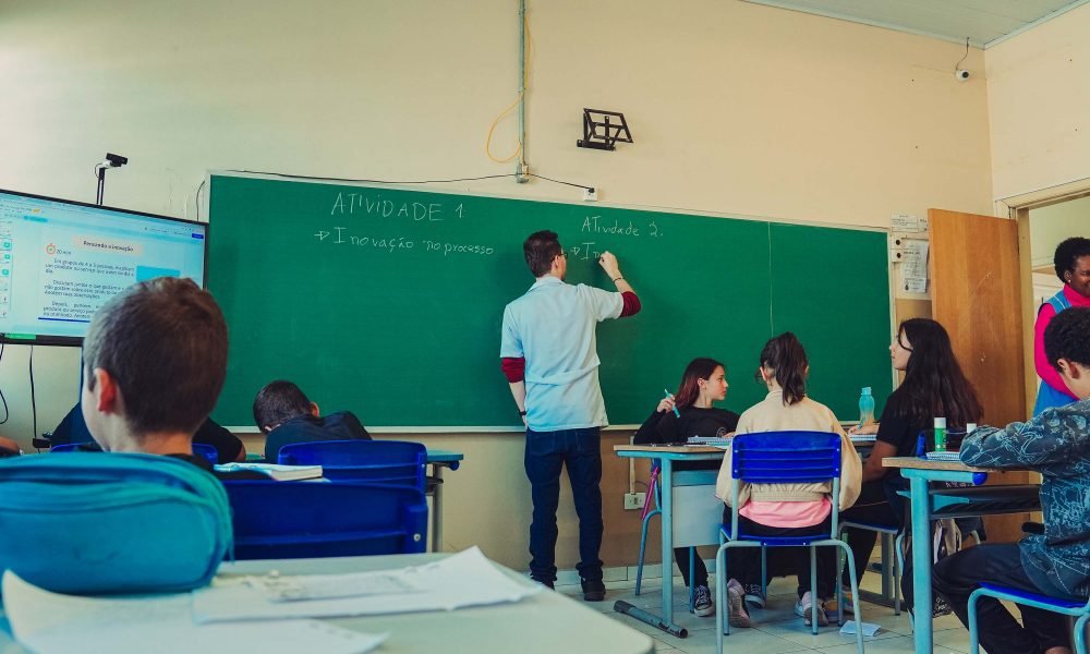 Imagem de um professor com sua turma em saa de aula