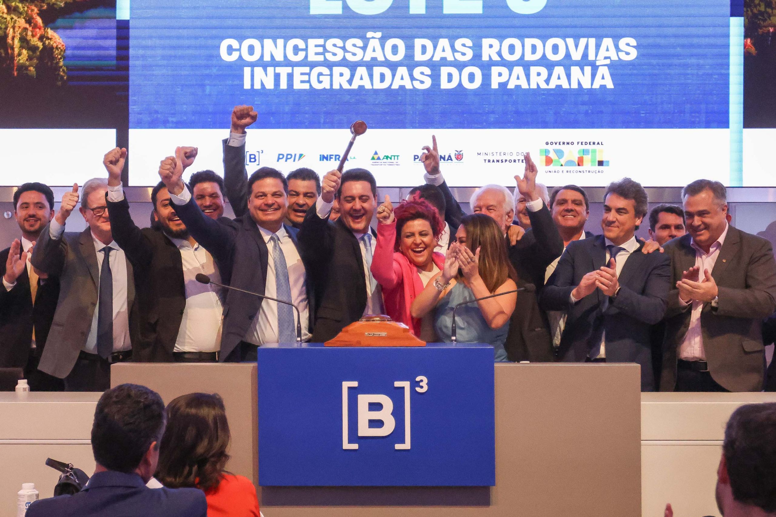 Cerimônia de assinatura da concessão das rodovias integradas do Paraná, com representantes e autoridades celebrando, marcando um novo marco para o transporte no estado.