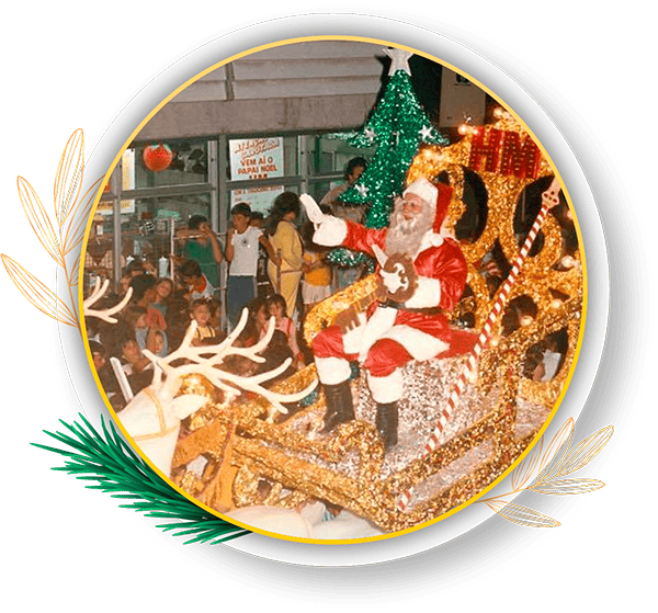 Papai Noel em carruagem decorada com luzes, cumprimentando crianças em evento natalino, cercado por uma árvore de Natal e público animado. Natal em Paranaguá é uma tradição rica em história, cultura e solidariedade