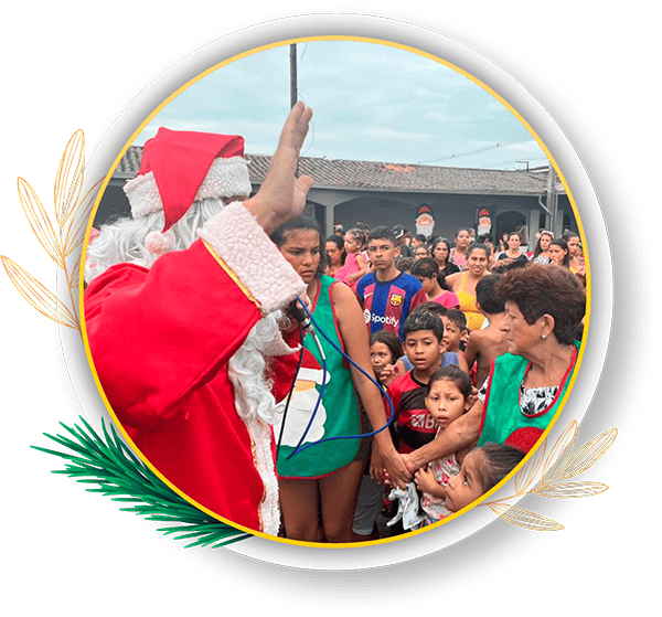 Uma celebração natalina com um Papai Noel interagindo com uma multidão de crianças e adultos. O evento traz alegria e união entre todos. Grupo Very Good: 24 anos exercendo a solidariedade no Natal em Paranaguá