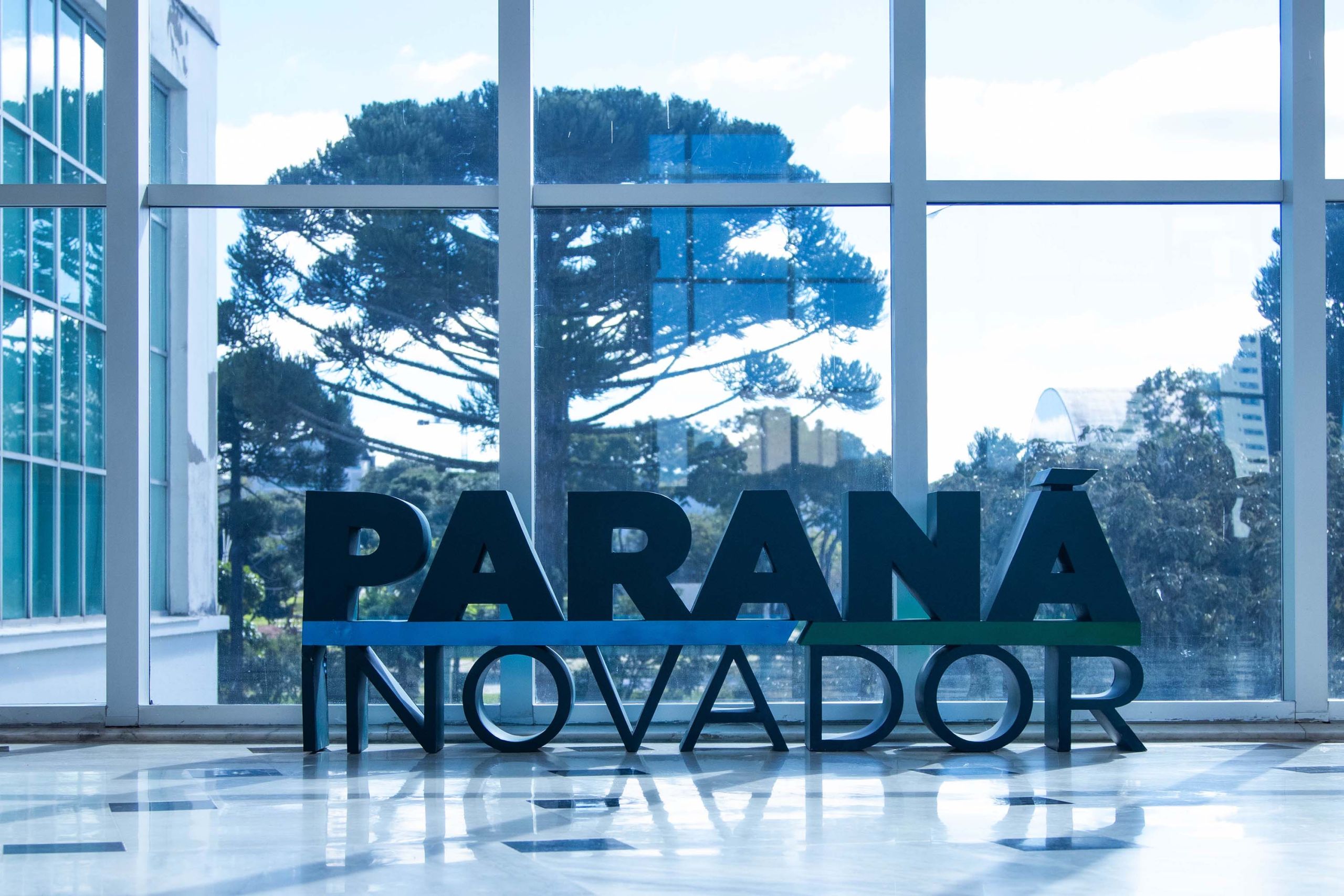 Imagem destacando a iniciativa Paraná Inovador, com seu logo em letras grandes e visíveis, em um ambiente iluminado e moderno, simbolizando inovação no estado do Paraná. Governo do Paraná vence prêmio nacional de transformação digital