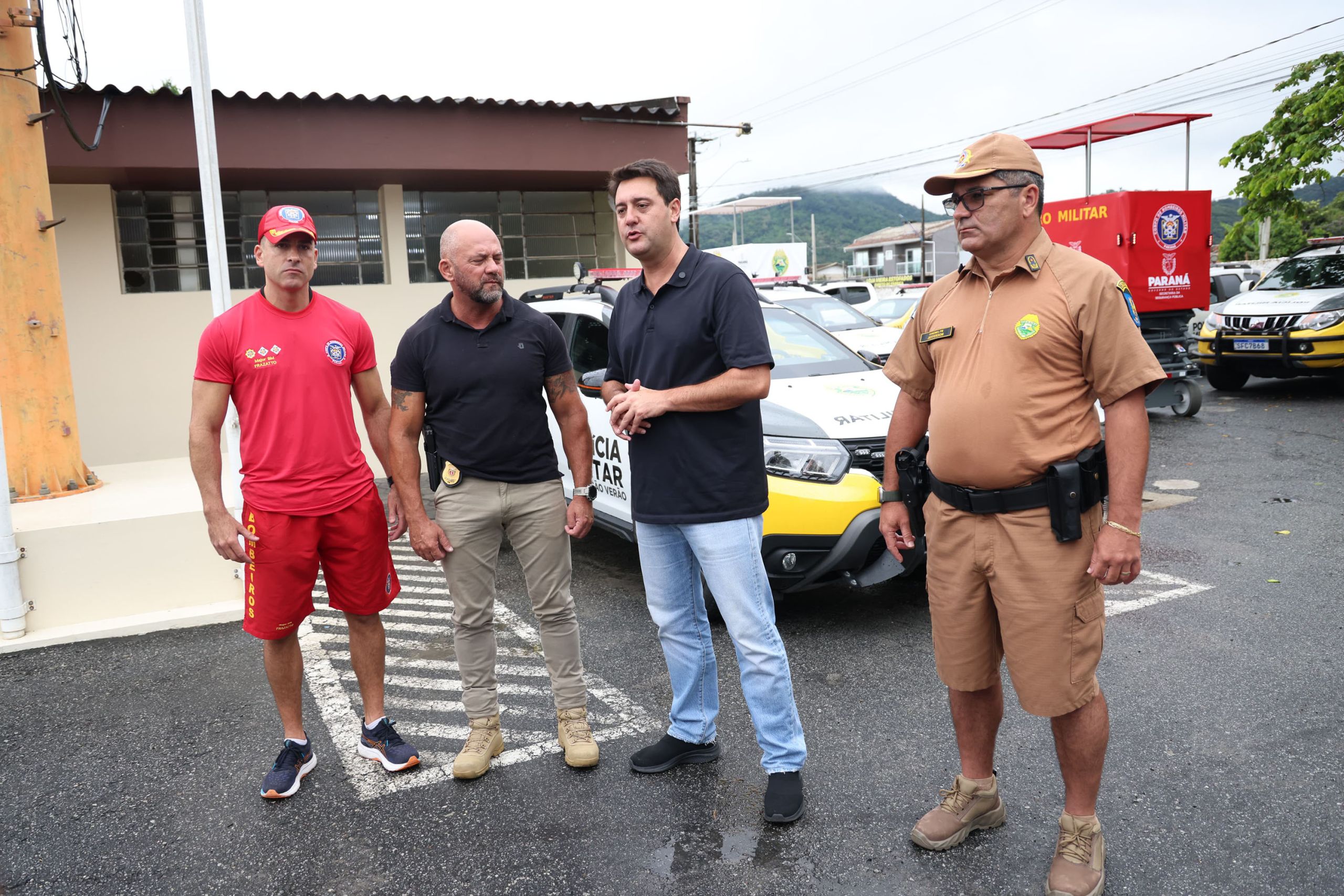 Foto de autoridades locais reunidas em frente a veículos de segurança, discutindo estratégias e ações para a segurança pública. Governador anuncia concurso público com 2.600 vagas para PM e Corpo de Bombeiros