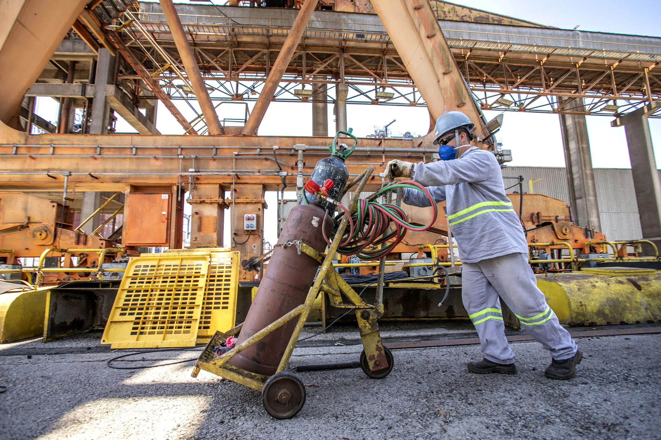 Trabalhador usando cilindro gás industrial em ambiente industrial, com foco na segurança e eficácia na operação. Com ritmo superior a estados mais populosos, Paraná é o 2.º que mais contrata no Brasil