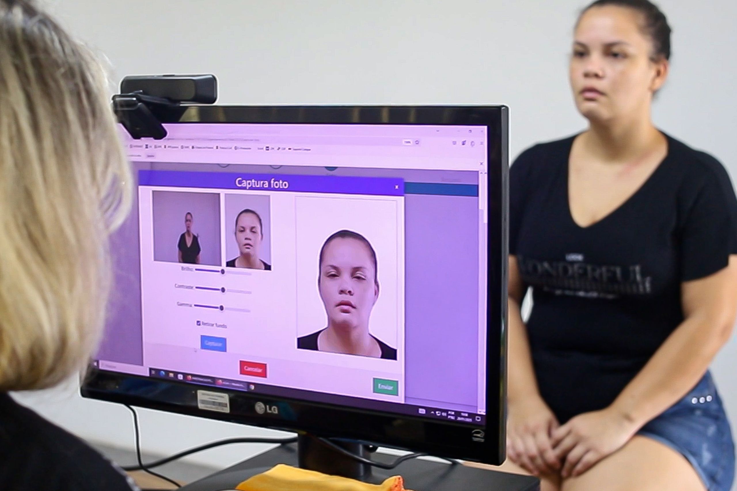 Pessoa sentada em frente a um computador, enquanto um software captura uma foto de seu rosto para análise de identidade ou reconhecimento facial. PCPR já emitiu 2,1 mil Carteiras de Identidade Nacional no litoral