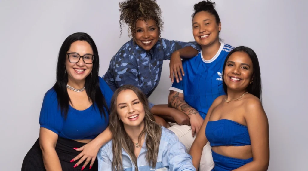 Grupo de amigas sorrindo, vestindo roupas azuis e exibindo alegria em um ambiente descontraído. A imagem exala amizade e boas vibrações. Palco Sunset: Banda Serena Flor e Banda Voraz estreiam nesta terça-feira em Caiobá