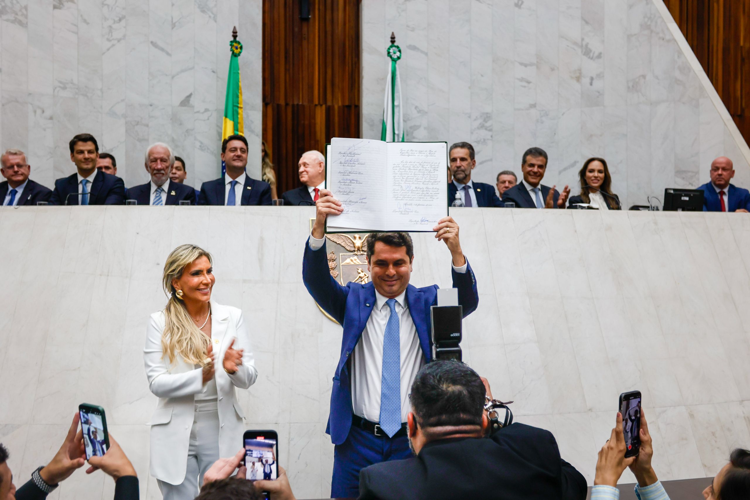 Cerimônia no Brasil com políticos e dignitários em destaque, aplaudindo um momento significativo e comemorativo no cenário político. Governador participa da posse do deputado Alexandre Curi como presidente da Alep