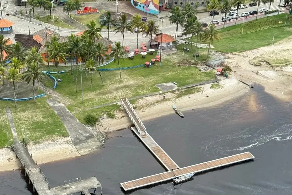 Vista aérea de uma região à beira mar com um cais, palmeiras e áreas de lazer, ideal para atividades de recreação e relaxamento. Com investimento de R$ 6,7 milhões, IAT começa a instalar novos flutuantes no litoral