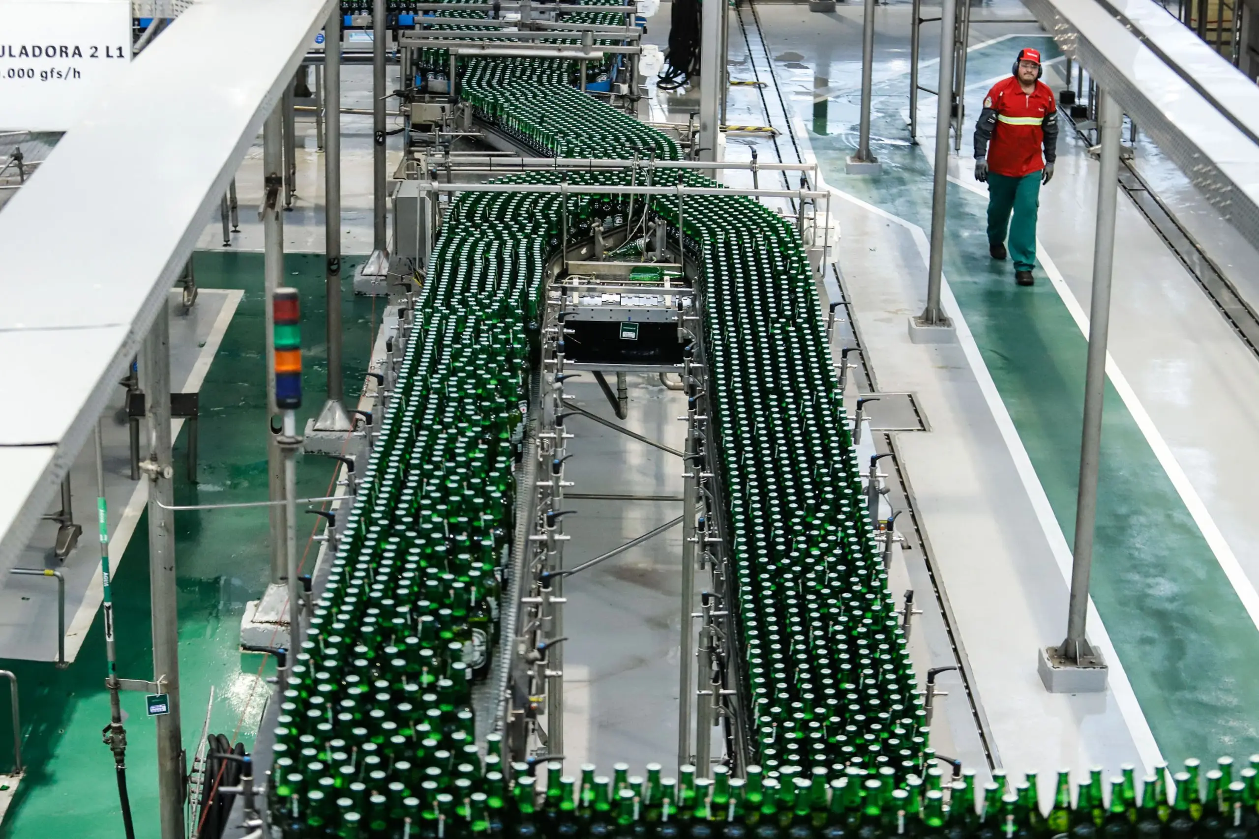 Imagem de uma linha de produção de garrafas verdes em uma fábrica, mostrando a eficiência na produção industrial de bebidas. Acima da média nacional, indústria do Paraná cresce 4,2% em 2024