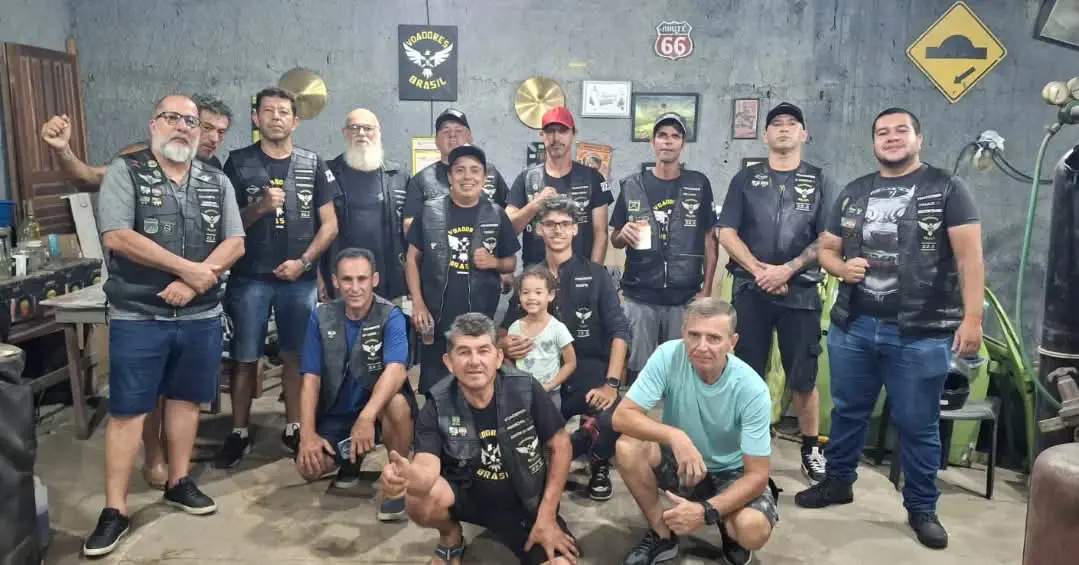 Grupo de motociclistas posando juntos em um ambiente descontraído, todos vestindo coletes e com sorrisos. Eles compartilham momentos de amizade e camaradagem, simbolizando a cultura de motoclubes. 9.º Aniversário do Motoclube Voadores Brasil acontece na Chácara Sintraport