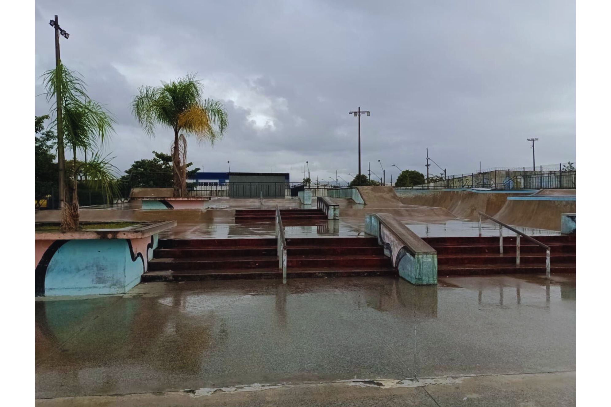 Skatepark molhado após a chuva, com rampas e escadarias visíveis, ideal para skatistas e amantes de esportes radicais. Mutirão Artístico: Paranaguá Mais Cores revitalizará pista de skate