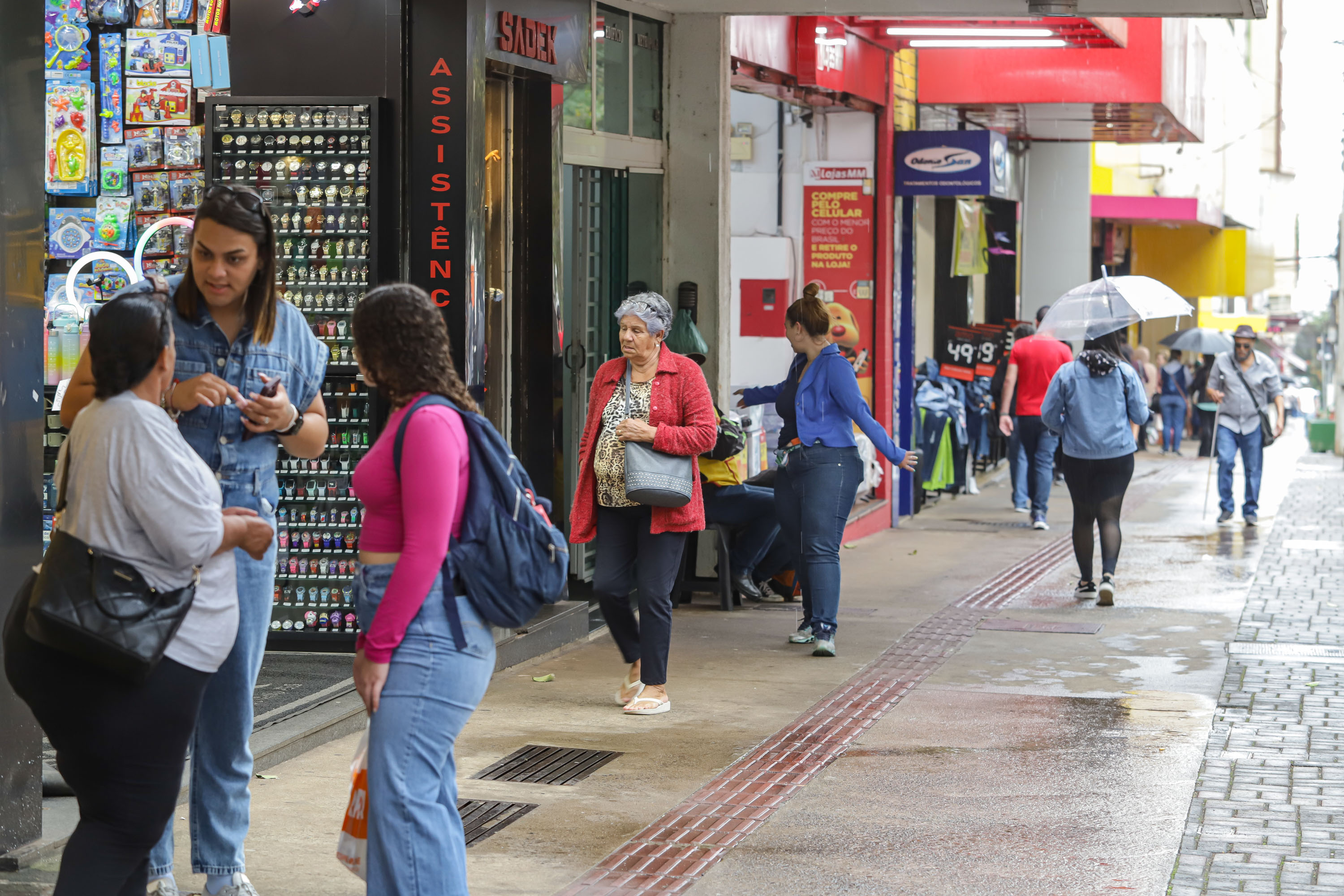 Imagem retratando um movimentado calçadão com pedestres interagindo e lojas ao fundo. Um cenário urbano que transmite a vida cotidiana. Melhor desempenho do País: Paraná lidera crescimento das vendas no comércio em março.