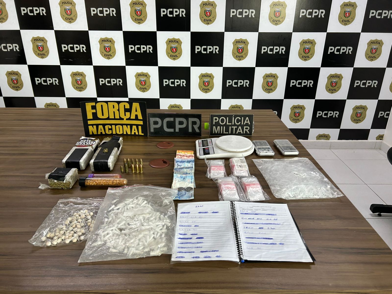 Forças policiais prendem suspeito de envolvimento em homicídio no bairro Santa Maria em Paranaguá 1 Drogas, cadernos com anotações do tráfico, embalagens plásticas, balanças de precisão e munições foram apreendidas durante o cumprimento das ordens judiciais