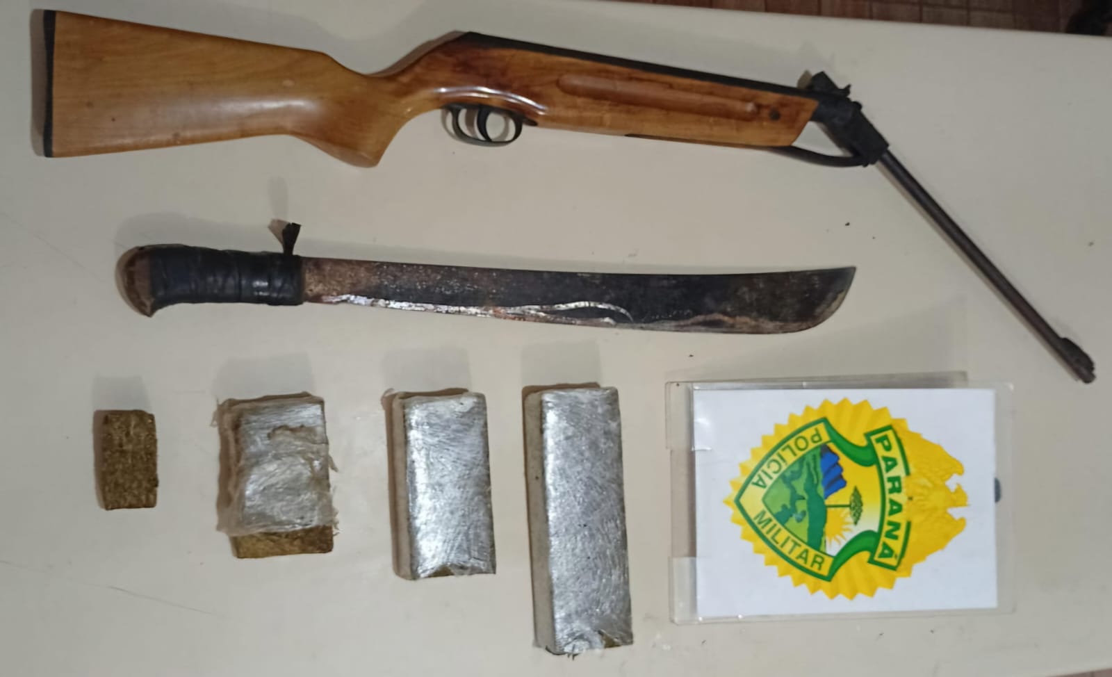 Acusado de envolvimento com o tráfico de drogas, ameaça e violência doméstica é preso pela PM em Pontal do Paraná 1 Os policiais apreenderam uma espingarda de pressão, um facão e porções e um tablete de maconha